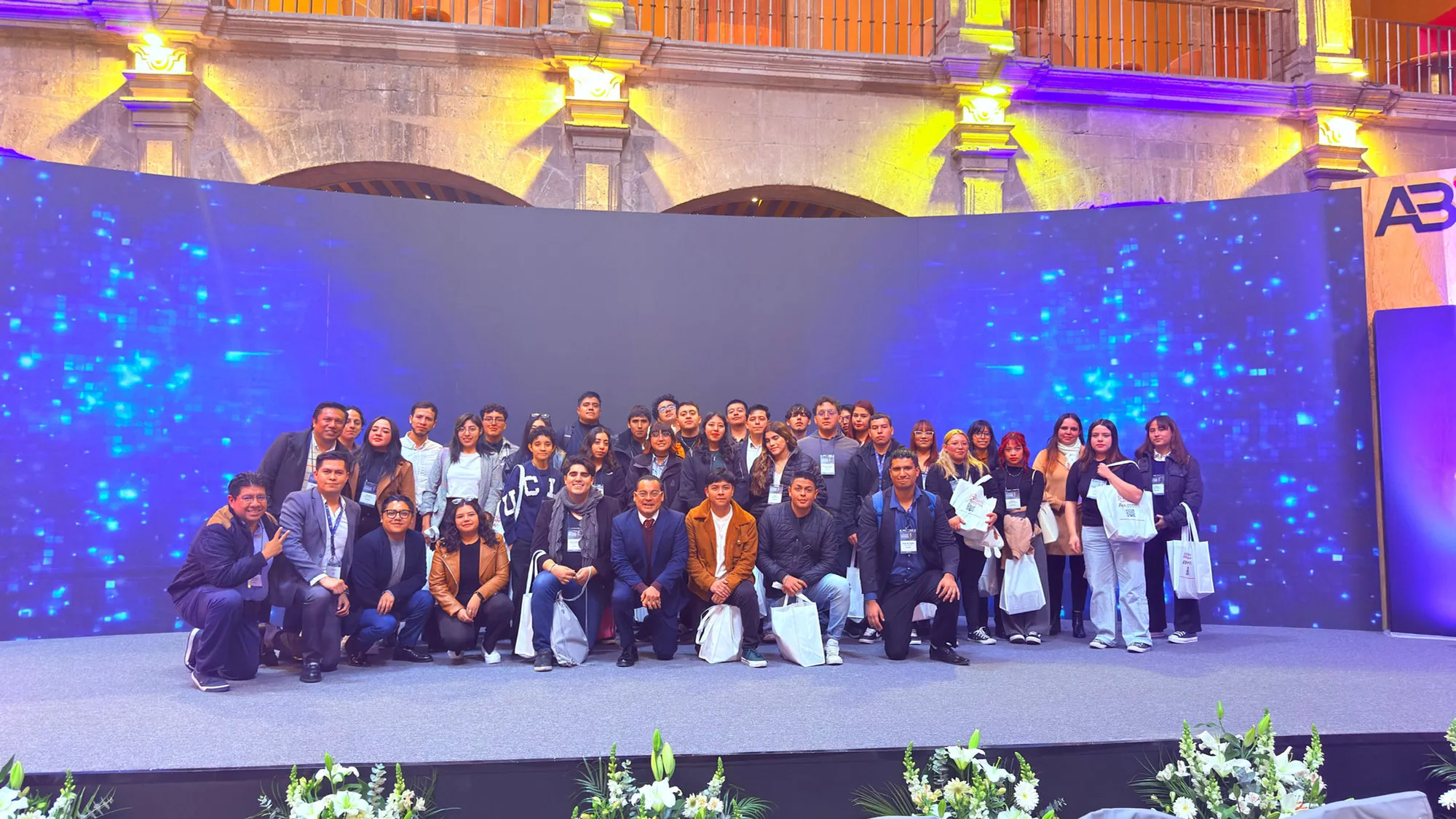 Grupo de aprendices y mentores del Modelo CAFÉ en el escenario de un evento